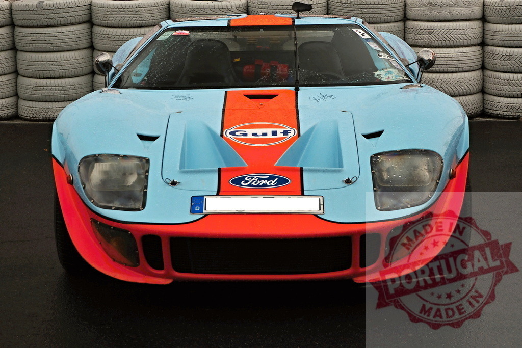 Ford GT40 vintage race car Gulf livery on track | Ford GT40 classic sports car with iconic Gulf livery parked on a wet track - Realized with Pictrs.com