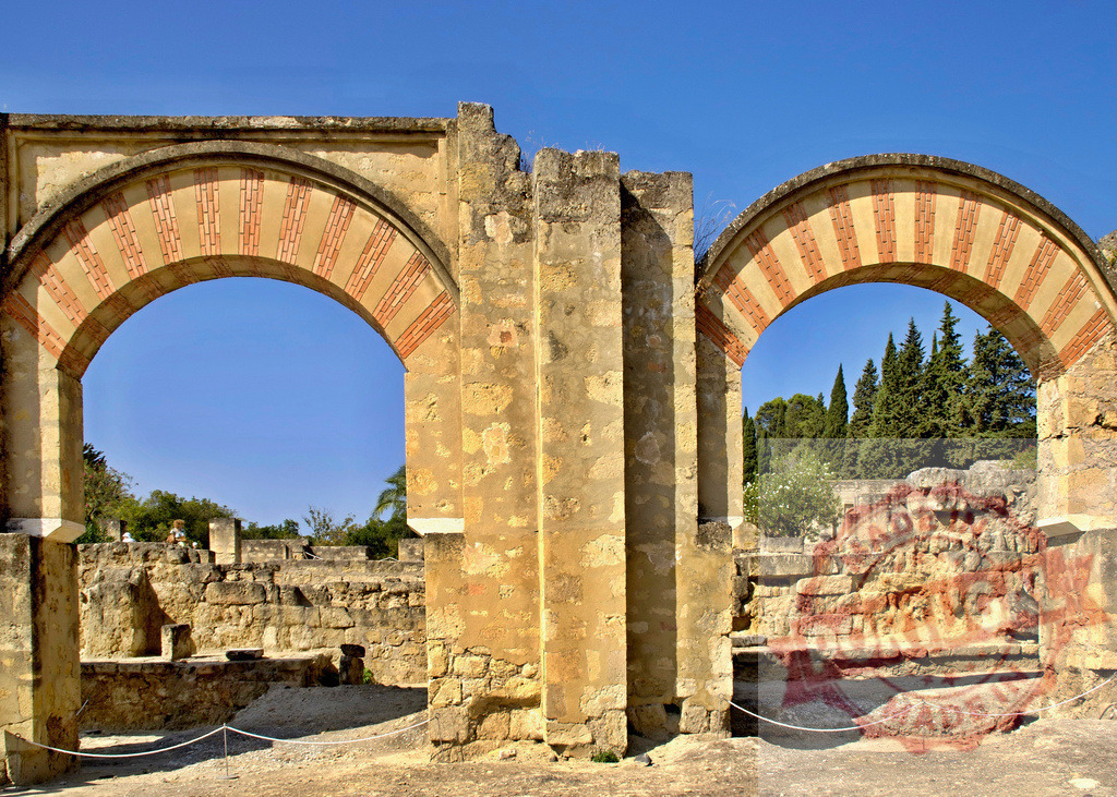 Medina Azahara ruins featuring Islamic horseshoe arches, Cordoba Spain. Spain - Cordoba | Ancient Medina Azahara palace architectural ruins with traditional Islamic arches under clear sky - Realized with Pictrs.com