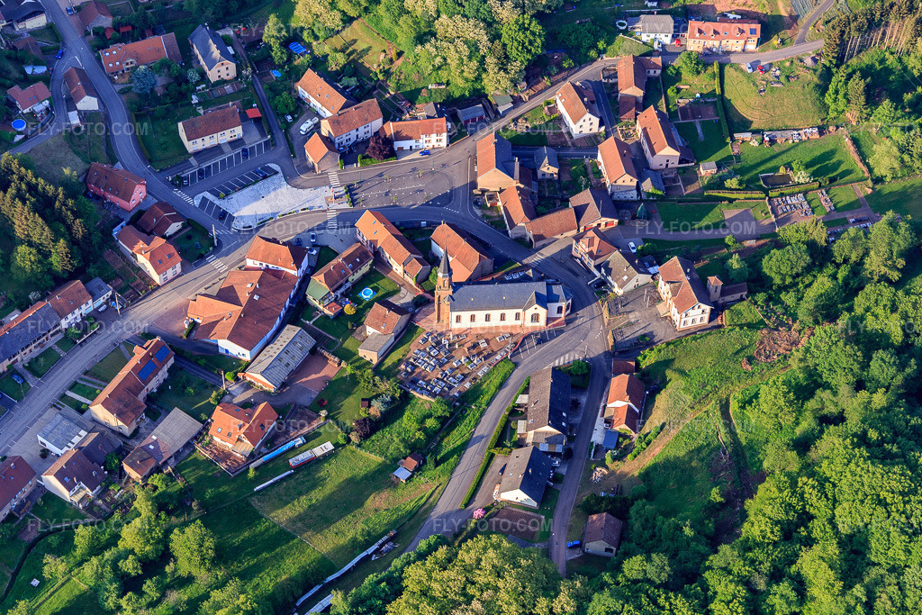 Aerial view: Cemetery and Eglise Saint Pierre in the village center in Hottviller in the state Moselle, France. – Photo: IMG_107224.jpg taken on 05/18/2018 by Werner Riehm/FLY-FOTO.com – Resolution of the original: 5226 x 3484 px – Archiprêtré de Bitche - Diocèse de Metz
