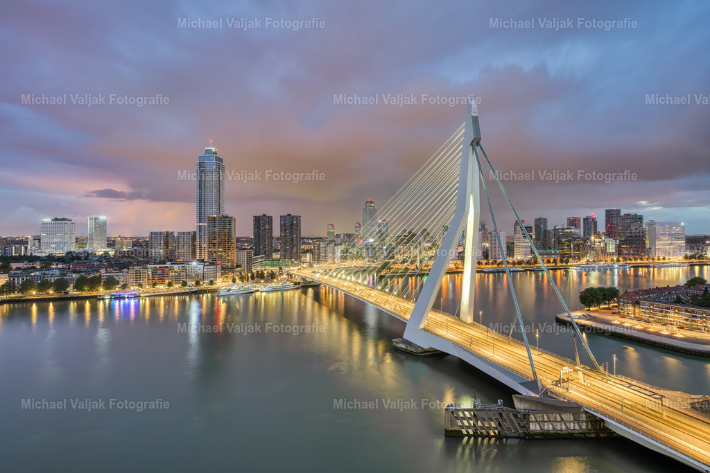 Rotterdam Erasmusbrücke und Skyline | Blick auf die Erasmusbrücke und die Skyline von Rotterdam am frühen Morgen. Der beginnende Sonnenuntergang wird von einem aufkommenden Regenschauer im Keim erstickt. Für einen Moment gibt es etwas Farbe am Himmel bevor es zu regnen beginnt und sich die Aussicht trübt. - Realisiert mit Pictrs.com