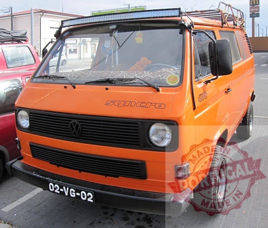 Volkswagen T3 Syncro van parked orange off-road camper | Orange Volkswagen T3 Syncro camper van with roof rack and LED bar ready for adventure - Realisiert mit Pictrs.com