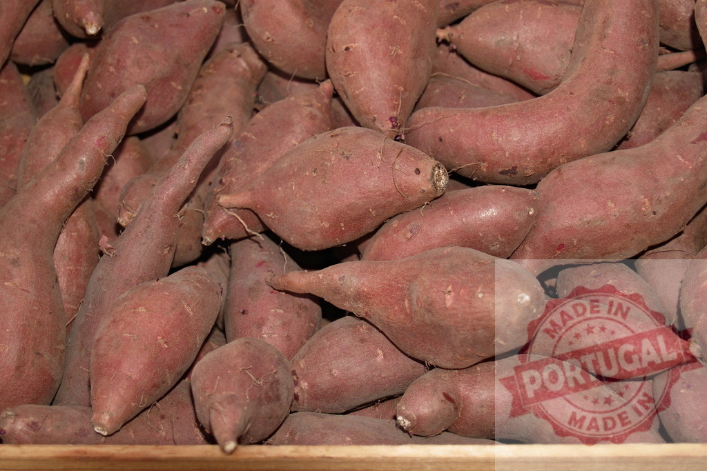 Red sweet potatoes filling a wooden crate at a market | Sweet potatoes piled in a rustic crate at market — fresh, organic root vegetables for healthy autumn cooking - Realized with Pictrs.com