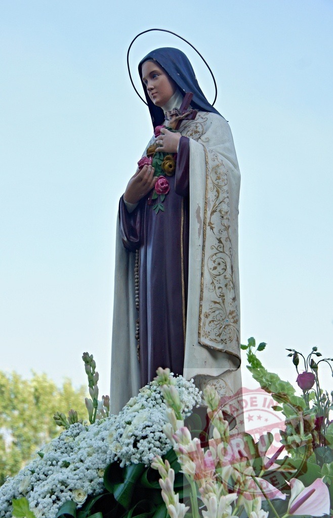 Statue of Saint Therese of Lisieux holding roses and wearing halo during religious celebration | Procession 15.08.2025 - Assumption Day - Paco de Sousa, Portugal Statue of Saint Therese of Lisieux holding roses, wearing halo and rosary beads, during religious celebration with flowers - Realisiert mit Pictrs.com