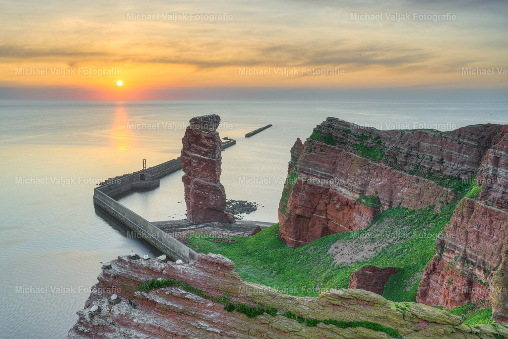 Lange Anna bei Sonnenuntergang | Blick zum Brandungspfeiler "Lange Anna" am Klippenende der Nordseeinsel Helgoland bei einem Sonnenuntergang im Mai. Die Felsnadel ist ein Wahrzeichen der Insel und akut einsturzgefährdet. Auf dem Felsen brüten im Frühjahr zahlreiche Vögel wie Basstölpel, Trottellummen und Dreizehenmöwen. - Realisiert mit Pictrs.com