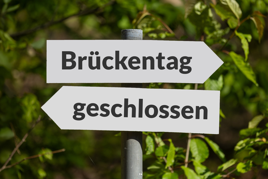 Brückentag geschlossen | (Fotomontage) Schilder im Wald mit hinzugefügtem Text BRÜCKENTAG und GESCHLOSSEN - Realisiert mit Pictrs.com