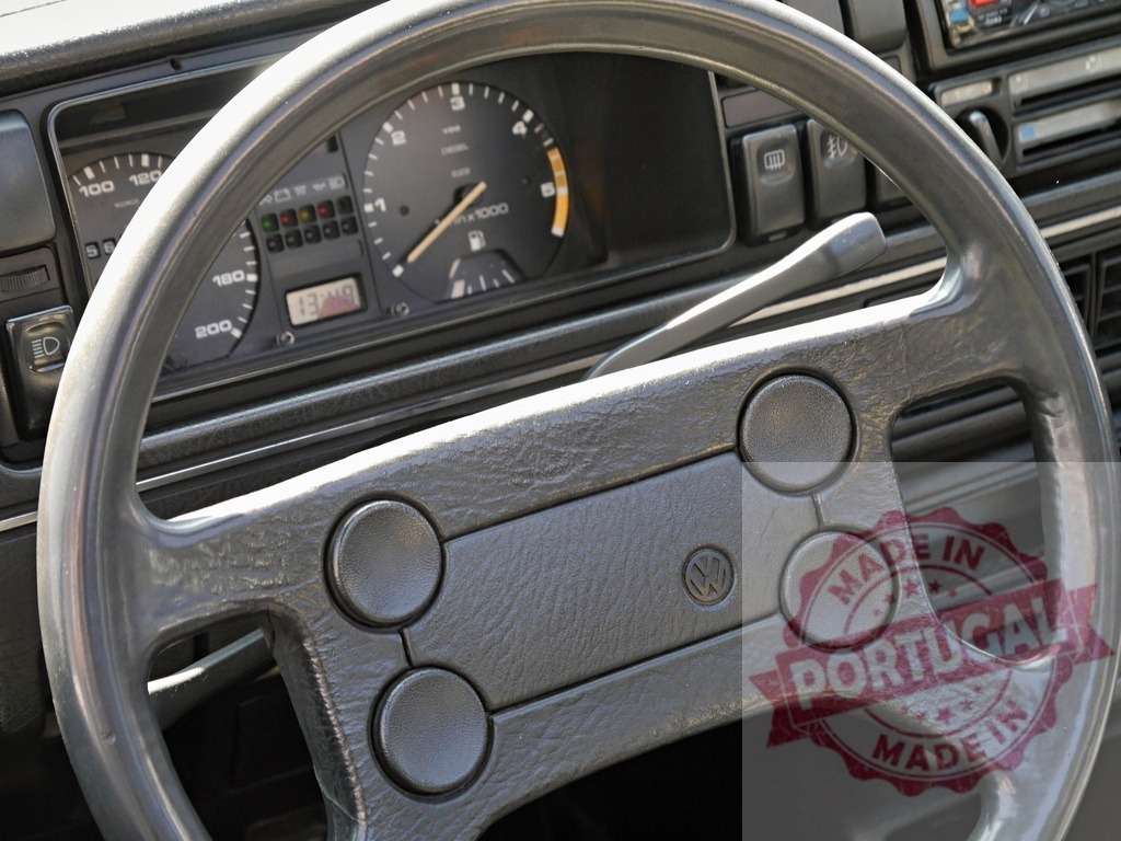 Volkswagen Golf Mk2 steering wheel and dashboard interior | Volkswagen Golf Mk2 steering wheel in gray plastic with dashboard showing gauges - Realized with Pictrs.com