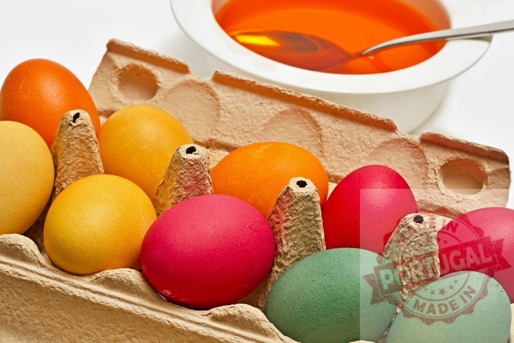 Colorful Easter eggs in carton with dyeing liquid | Many colorful painted Easter eggs filling a carton with dying liquid in a bowl - Realized with Pictrs.com