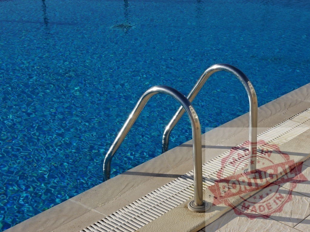 Swimming pool ladder leading into refreshing blue water | Swimming pool ladder providing access to inviting deep blue water on a sunny day - Realisiert mit Pictrs.com