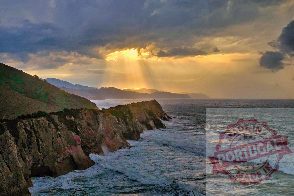 Sunset crepuscular rays over ocean cliffs | Sun rays breaking through clouds over a rugged coastline with crashing waves - Realisiert mit Pictrs.com