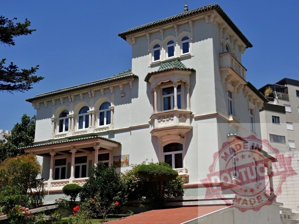 Historic villa building with decorative bay windows. Aveiro - Portugal | Ornate architecture, columns, and a garden under a clear blue sky - Realized with Pictrs.com