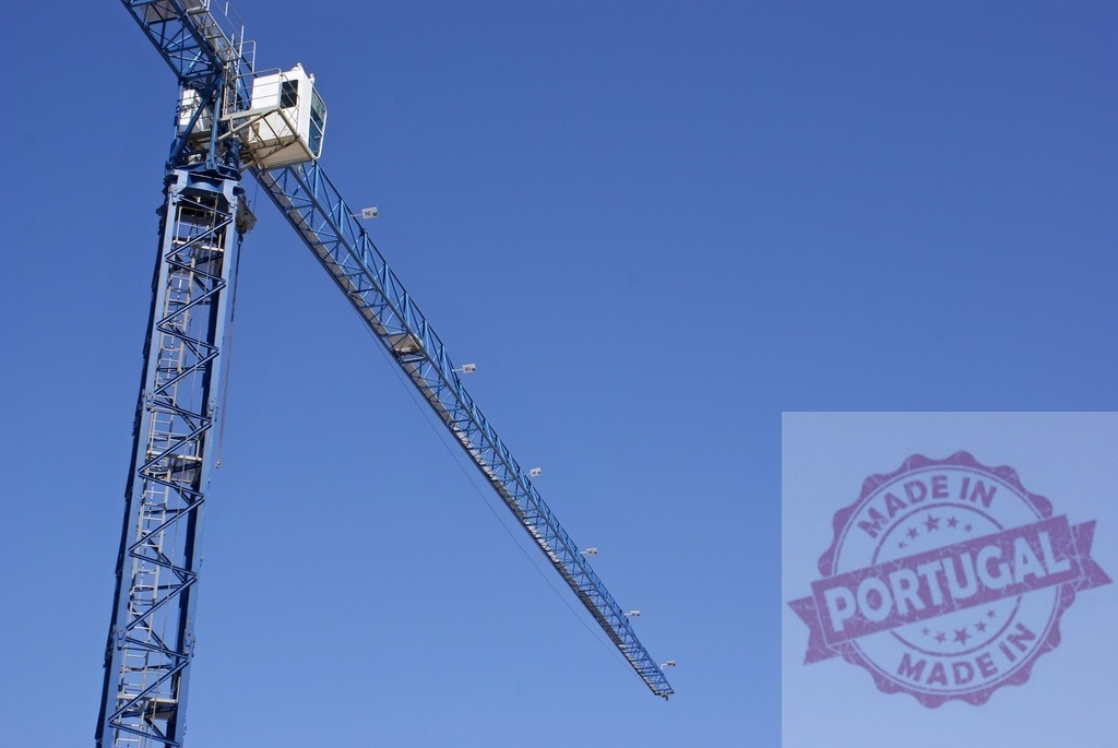 Blue tower crane against clear sky at construction site | Blue tower crane extending across a clear deep blue sky, symbolizing construction and development - Realized with Pictrs.com