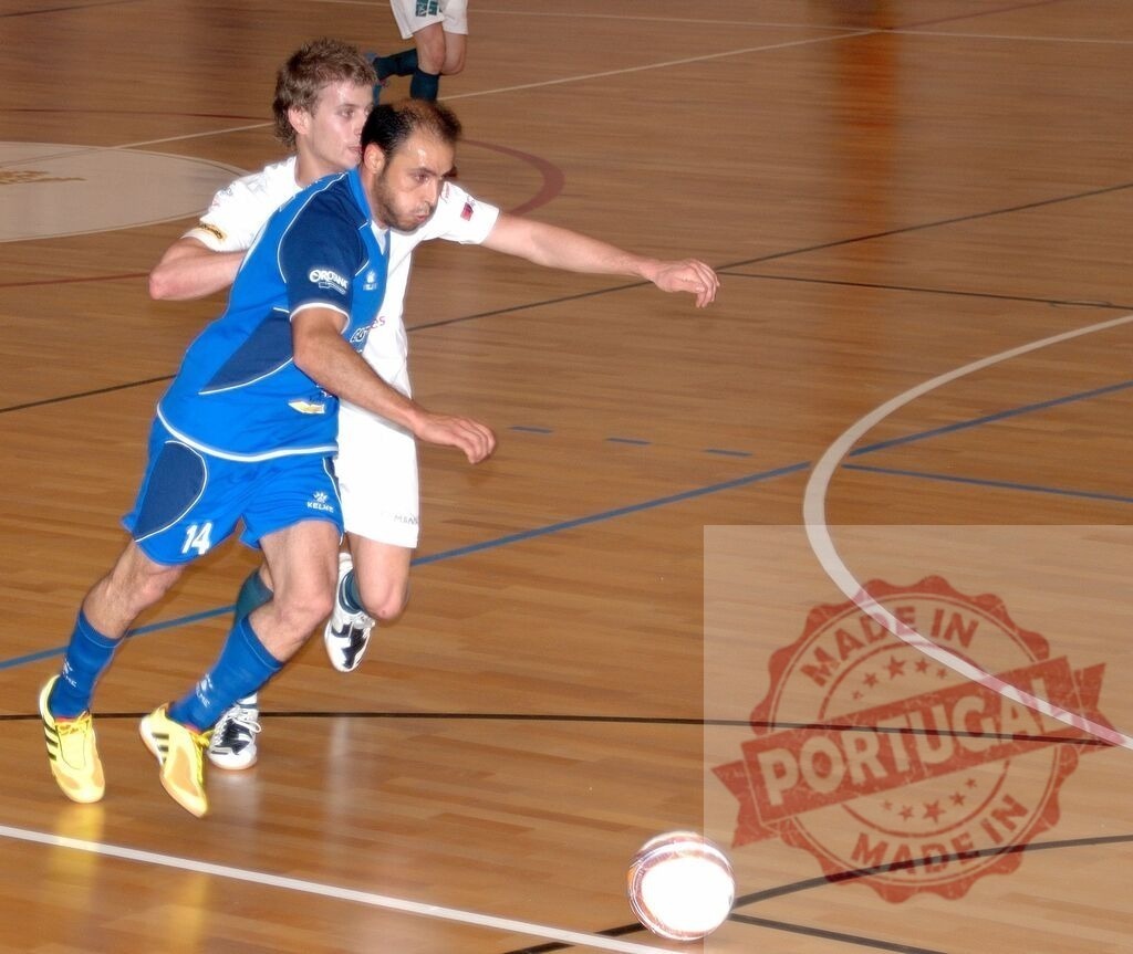 Futsal player in blue uniform tackling opponent during match | Two futsal players competing for the ball during an intense match - Realisiert mit Pictrs.com