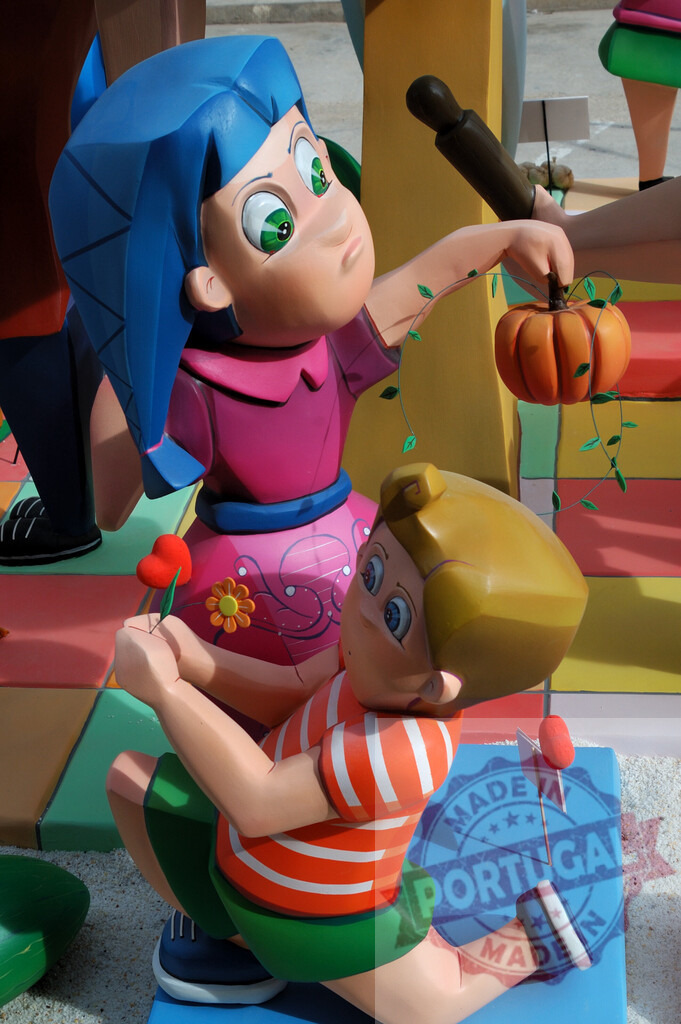 Las Fallas festival cartoon characters celebrating tradition. Fallas Fiestas Communidad Valenciana | Cartoon ninot characters displaying a pumpkin and a heart flower at Las Fallas festival - Realisiert mit Pictrs.com