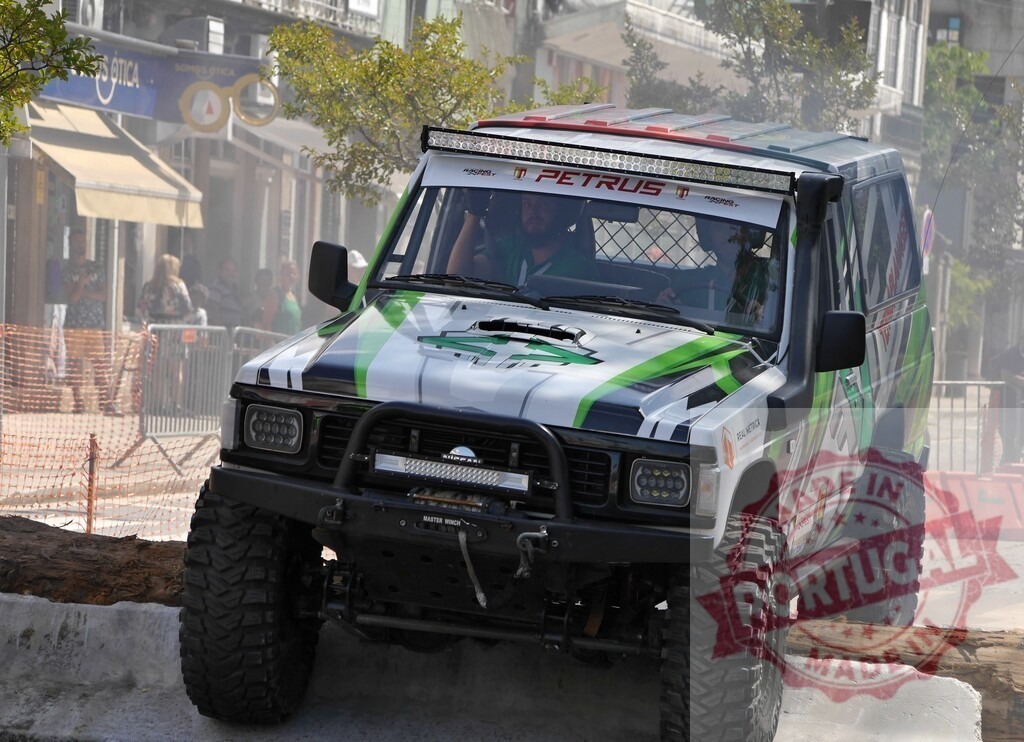 Nissan patrol climbing over a log during an urban offroad competition | Tuned nissan patrol overcoming obstacles during an urban offroad competition - Realized with Pictrs.com