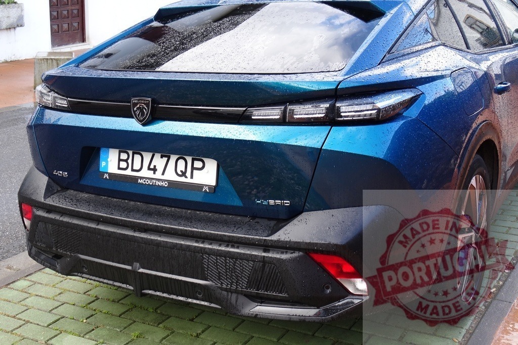 Peugeot 408 plugin hybrid car on rainy street | Blue Peugeot 408 plugin hybrid SUV coupe parked on a wet day - Realisiert mit Pictrs.com