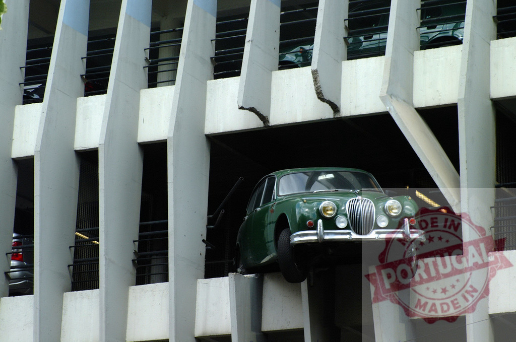 Green Jaguar car crashing out of a parking garage wall | Green Jaguar classic car crashing through the wall of a concrete parking garage - Realized with Pictrs.com
