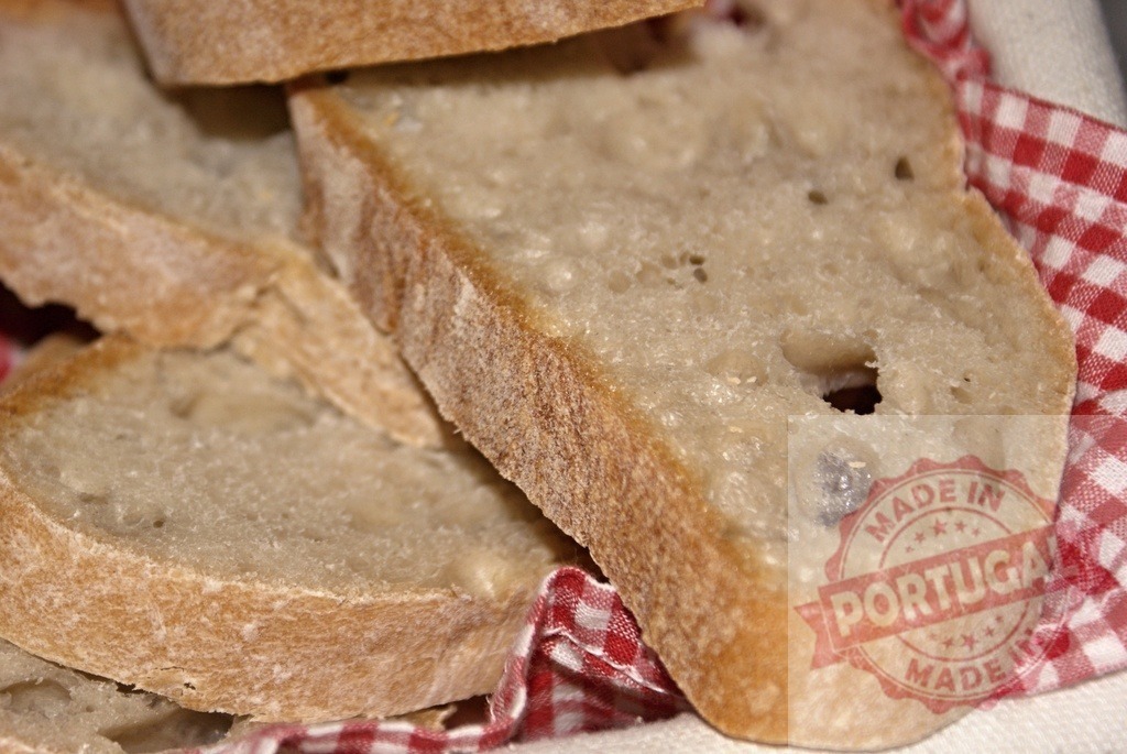 Slices of rustic bread with crust and red napkin | Slices of fresh rustic bread in a red gingham napkin, ready to eat - Realized with Pictrs.com