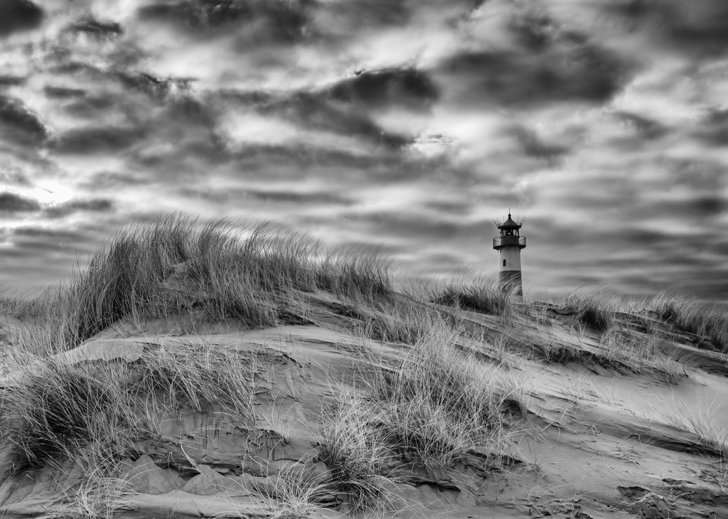 deutschland-2018-561 | Dünen, Heide, weiter Sandstrand und das Meer prägen im Norden der Insel Sylt das Naturschutzgebiet Ellenbogen, auf dem zwei weithin sichtbare Leuchttürme stehen. Hier ist das Ostfeuer zu sehen, das die Dünenlandschaft am östlichsten Ende, der Ellenbogenspitze, überragt. - Realisiert mit Pictrs.com