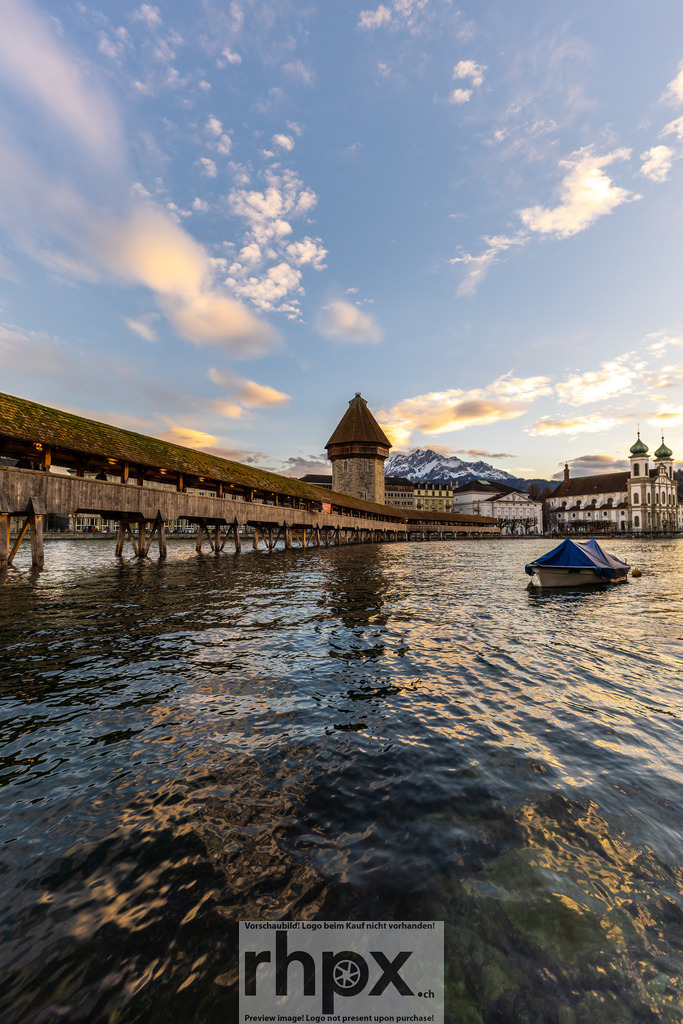 Kapellbrücke Luzern mit Pilatus | Holz. Wasser. Bergmassiv. Der Blick gleitet entlang der weltberühmten Kapellbrücke hin zum markanten Gipfel des Pilatus. Das Zusammenspiel von historischem Bauwerk und wilder Bergwelt prägt diese einzigartige Luzerner Kulisse in warmem Abendlicht. Wähle unter "Produktauswahl" dein Wunschformat: Vom klassischen Wandbild über Puzzle &amp; Tassen bis zum digitalen Download (z.B. als Handy-Hintergrund). - Realisiert mit Pictrs.com