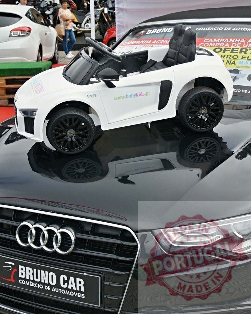Audi toy car displayed on a luxury automobile hood | White toy Audi R8 car standing on the black hood of an Audi Q5 - Realized with Pictrs.com
