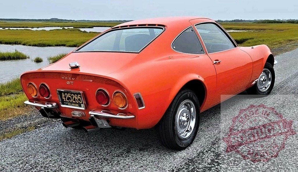 Orange Opel GT vintage sports car on coastal road | Orange Opel GT classic coupe parked on a gravel road next to marshland and water - Realisiert mit Pictrs.com