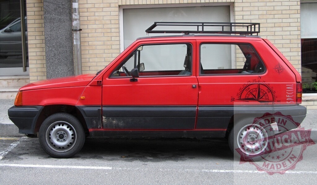 Red Seat Marbella parked on the street displaying a wind rose | Small red city car parked on the side of a brick building with a wind rose sticker - Realized with Pictrs.com