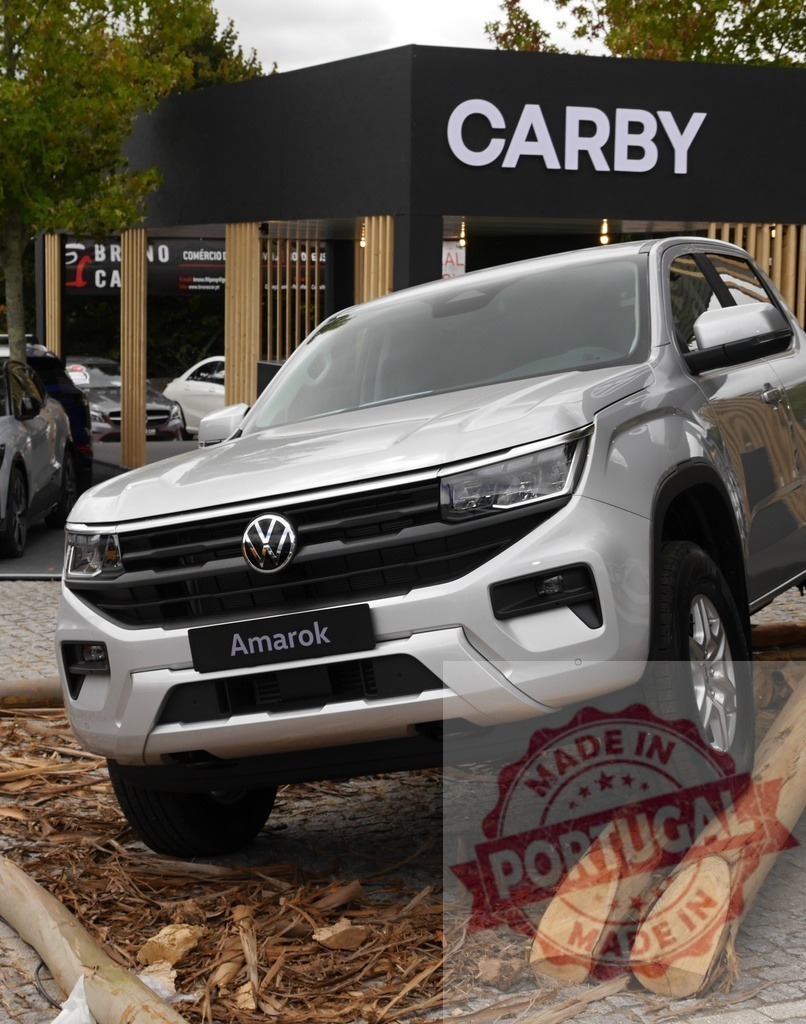 Volkswagen Amarok pickup truck off-road display at Carby | Silver Volkswagen Amarok pickup truck showcasing off-road capability on wood logs at a Carby dealership - Realisiert mit Pictrs.com