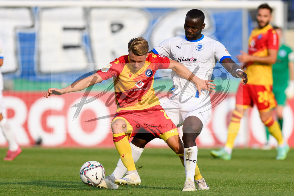LOTKSC20210809_174 | Fussball, Herren: Marco Thiede (Karlsruher SC) und Exauce Andzouana (Sportfreunde Lotte) im Zweikampf beim Spiel der 1. Runde im DFB-Pokal zwischen SF Lotte und Karlsruher SC im Stadion am Lotter Kreuz am 09.08.2021 in Lotte, Deutschland.DFB / DFL REGULATIONS PROHIBIT ANY USE OF PHOTOGRAPHS AS IMAGE SEQUENCES AND/OR QUASI-VIDEO. - Realisiert mit Pictrs.com