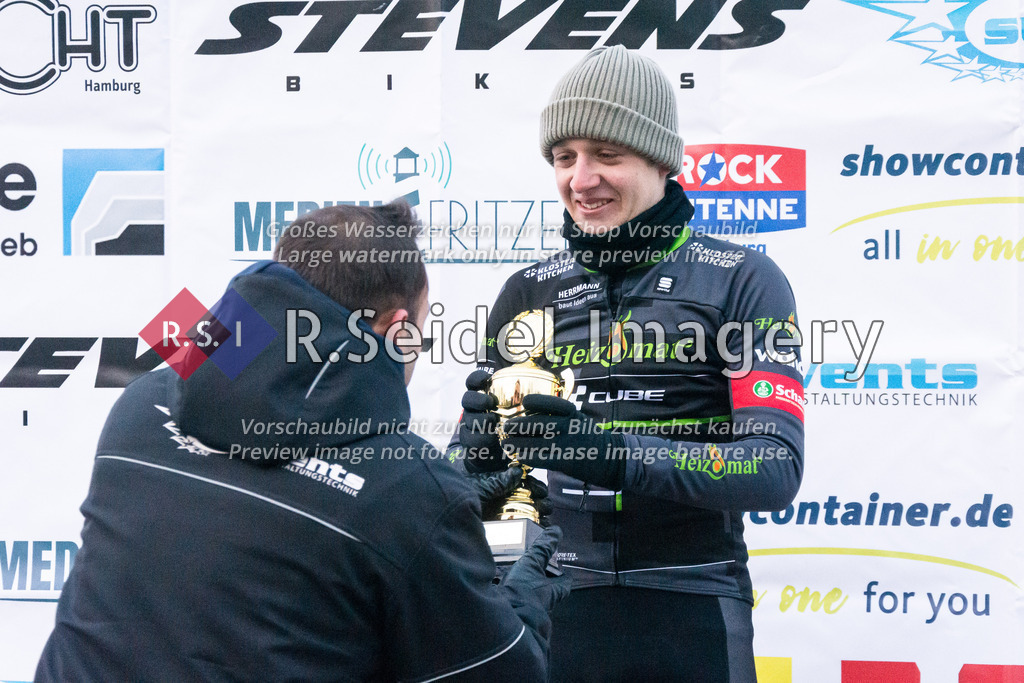 Radsport, 14. Lauf - Bikebeat Cyclo-Cross Bundesliga 2022/23 und 43. Harburger Weihnachtspreis im Stevens Cup 2022, Schwarzenbergplatz (Hamburg-Harburg), 18.12.2022 | Nach dem Rennen 6 / Männer Elite (Lizenzfahrer): 
Borhen Azzouz (subevents & Harburger RG) übergibt Jasper Levi Pahlke (#13, Heizomat Radteam p/b Kloster Kitchen) den Pokal für den 3. Platz.