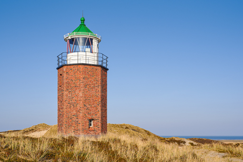 Leuchtfeuer Rotes Kliff | Das Quermarkenfeuer Rotes Kliff auf der Insel Sylt im Frühjahr. Bei klarer Sicht zeigt sich im Hintergrund die Nordsee. — Auflösung des Originals: 5787 x 3858 px. - Realisiert mit Pictrs.com