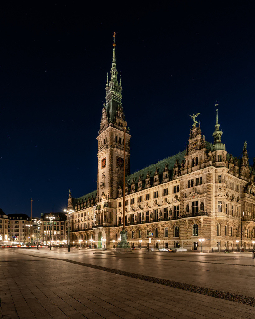 Hamburger Rathaus bei Nacht | Das beleuchtete Hamburger Rathaus erhebt sich in der Dunkelheit über dem Rathausmarkt. Die historische Fassade und der markante Turm kommen durch die nächtliche Beleuchtung besonders eindrucksvoll zur Geltung. - Realisiert mit Pictrs.com