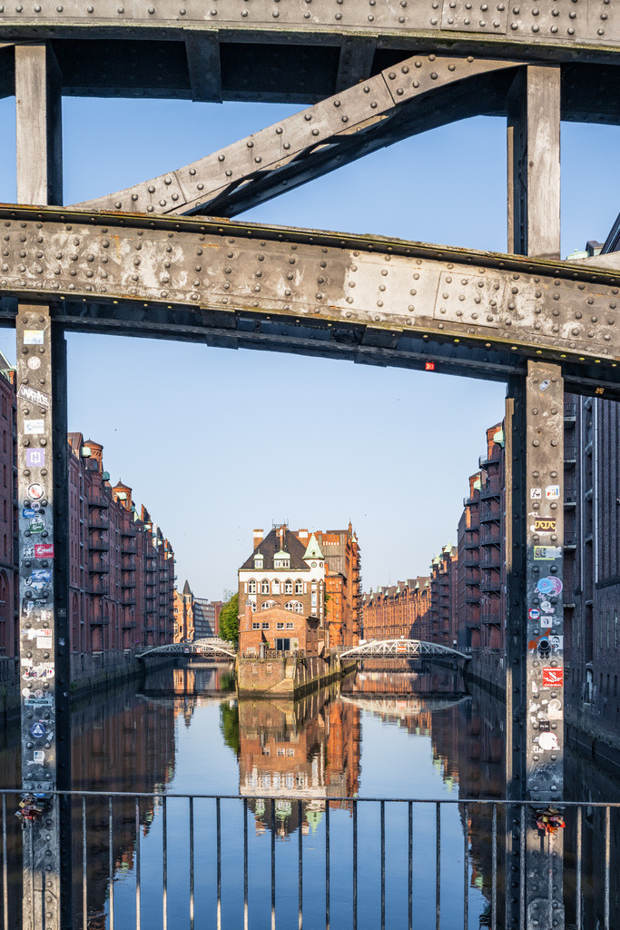 Gerahmter Blick auf die Speicherstadt | Besondere Perspektive auf die Hamburger Speicherstadt, eingerahmt durch eine Brückenkonstruktion mit Blick auf das Fleet und die Backsteinfassaden. - Realisiert mit Pictrs.com