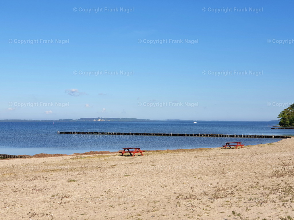Strand in Lietzow mit Bänken | Ruhige Szene in den Morgenstunden am Großen Jasmunder Bodden der Insel Rügen am Lietzower Strand mit Bänken - Realisiert mit Pictrs.com