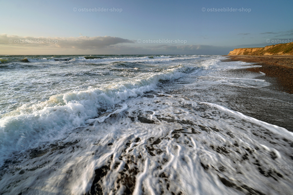 Schaumkronen malen Wellenmuster in den nassen Sand | Mit knisternder Gischt erreichen Wellen in dichten Abständen den Ostseestrand. Beim Vor- und Zurückfliessen des Wassers entstehen immer neue Wellenmuster.