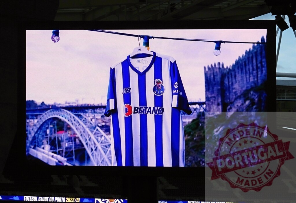 FC Porto football jersey on screen with Porto landmarks | FC Porto football jersey displayed on a stadium screen with the Luís I Bridge and a castle - Realized with Pictrs.com