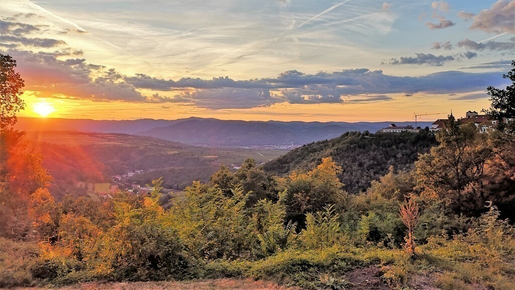 abendliches Fernweh with romantic vibrations | Diese malerische Fotografie hat den Blick vom Hügel, auf dem einst die Kirche St. Georg stand, vorbei am Stift Göttweig in Richtung Stein an der Donau an einem lauen Sommerabend festgehalten.Die südländisch anmutende Vegetation lässt, obwohl im Donauraum, bei so manchen Betrachter eine Sehnsucht an eine Meeresküste aufkommen.Dort sowie hier regt der Blick in die Weite die Fantasie an und die warmen Farbtöne beim Sonnenuntergang lassen eine romantische Stimmung aufkommen.