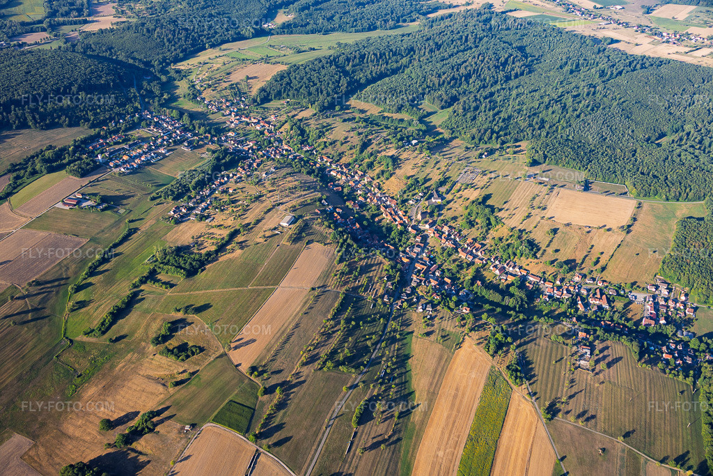Aerial view: View of the town from the northeast in Langensoultzbach in the state Bas-Rhin, France. – Photo: IMG_158236.jpg taken on 07/25/2026 by Werner Riehm/FLY-FOTO.com – Resolution of the original: 6000 x 4000 px