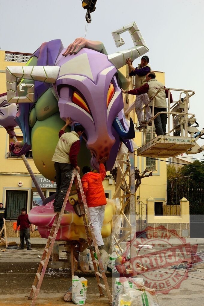Building a Ninot sculpture for Las Fallas festival in Valencia | Workers assembling a large, colorful Ninot sculpture using ladders, a crane, and a lift - Realized with Pictrs.com