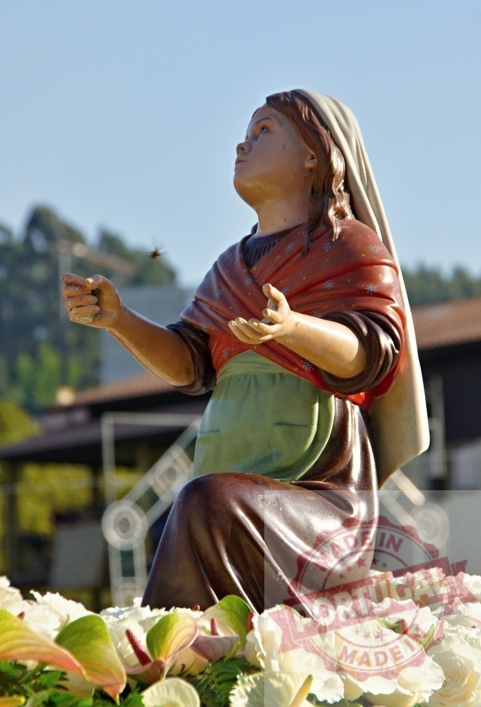 Statue of young Saint Jacinta Marto praying in Fatima, Portugal | Procession 15.08.2025 - Assumption Day - Paco de Sousa, Portugal Statue of young Saint Jacinta Marto praying, decorated with flowers during a procession in Fatima, Portugal - Realisiert mit Pictrs.com