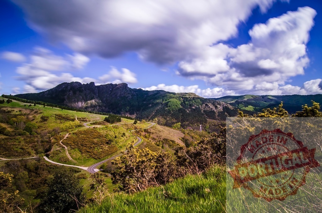 Winding road crossing green valley under cloudy sky in Auvergne, France | Breathtaking landscape with a winding road crossing a green valley under a cloudy sky in Auvergne, France - Realisiert mit Pictrs.com
