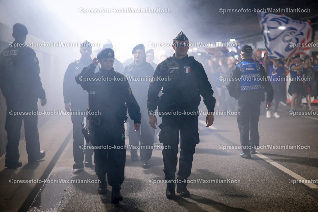 HHmx05072401015 | 05.07.2024, Hamburg, EURO2024 FRANCE VS PORTUGAL Fans and Unterstützer von Frankreich vor dem Fußballspiel zwischen der Nationalmannschaft  von France (les Bleus) und Portugal im Viertelfinale knock out game der UEFA EURO, EM, Europameisterschaft, Fussball 2024 tournament. Fanmarsch von Schnellingen zum Stadion vor dem Spiel. Polizeibeamte sichern den Fanmarsch