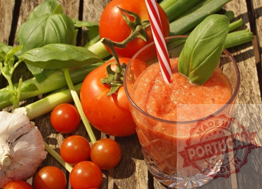 Refreshing tomato smoothie with basil and fresh vegetables | Tomato smoothie with straw and basil leaf, surrounded by fresh garlic, basil, green onion, and tomatoes - Realized with Pictrs.com