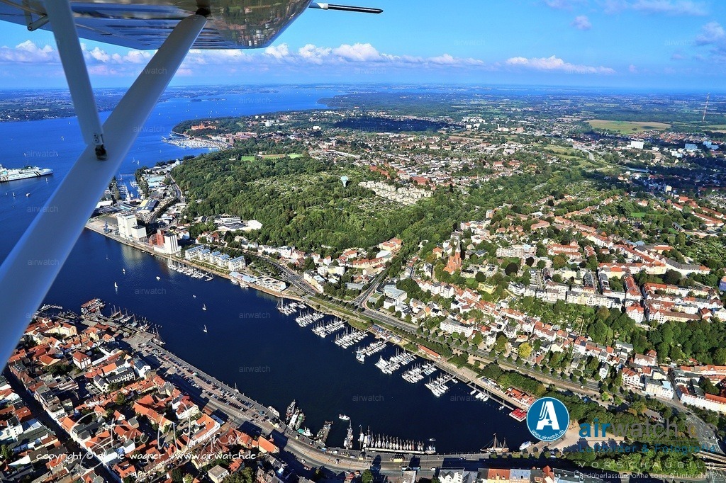 Luftbild Flensburger Hafen - Die Hafenspitze ist der nördliche Abschluss des Flensburger Hafens | Die Hafenspitze ist der nördliche Abschluss des Flensburger Hafens an der Flensburger Förde und ein beliebter öffentlicher Platz in der Innenstadt. Bis in die 1980er Jahre befand sich dort der Kanalschuppen; heute dient die große Freifläche als Veranstaltungsort für Events wie das Weltgenüsse-Festival (6.–9. Juni 2025) und andere gastronomische oder kulturelle Highlights.