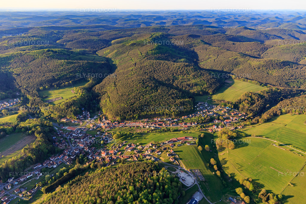 Aerial view: View of a town in the Northern Vosges Mountains from the south in Reipertswiller in the state Bas-Rhin, France. – Photo: IMG_145798.jpg taken on 04/30/2025 by Werner Riehm/FLY-FOTO.com – Resolution of the original: 5313 x 3542 px