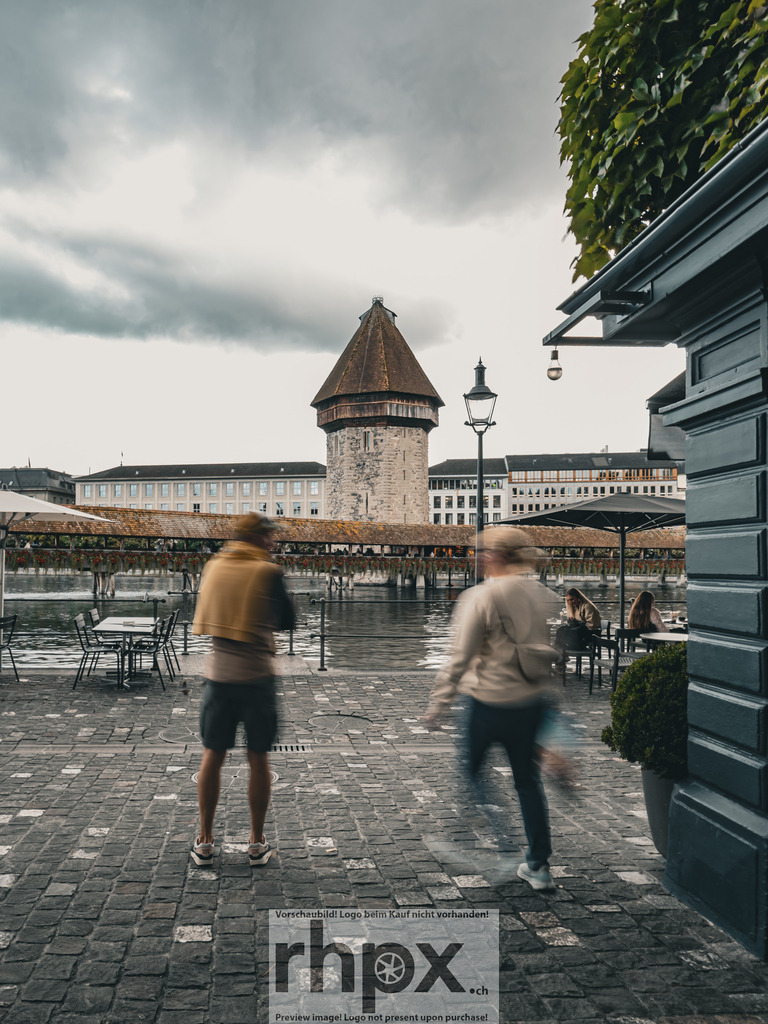 Zeitgeist | Rhythmus. Stein. Zeitgeist.Das pulsierende Leben auf dem Luzerner Kopfsteinpflaster verschmilzt mit der Beständigkeit der historischen Kapellbrücke. Die bewusste Bewegungsunschärfe verleiht dieser Szenerie eine moderne Dynamik inmitten jahrhundertealter Architektur.Wähle unter "Produktauswahl" dein Wunschformat: Vom klassischen Wandbild über Puzzle &amp; Tassen bis zum digitalen Download (z.B. als Handy-Hintergrund). - Realisiert mit Pictrs.com