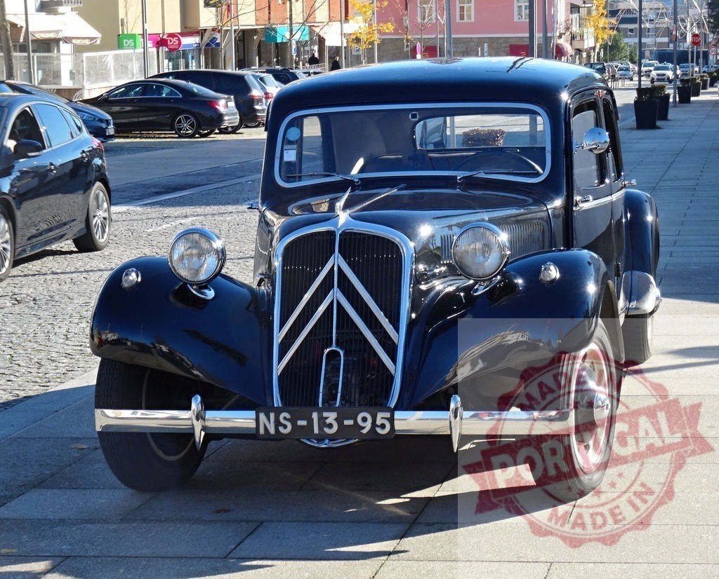 Black Citroën Traction Avant classic car on urban street | Black vintage Citroën Traction Avant parked on a city street during the day - Realized with Pictrs.com