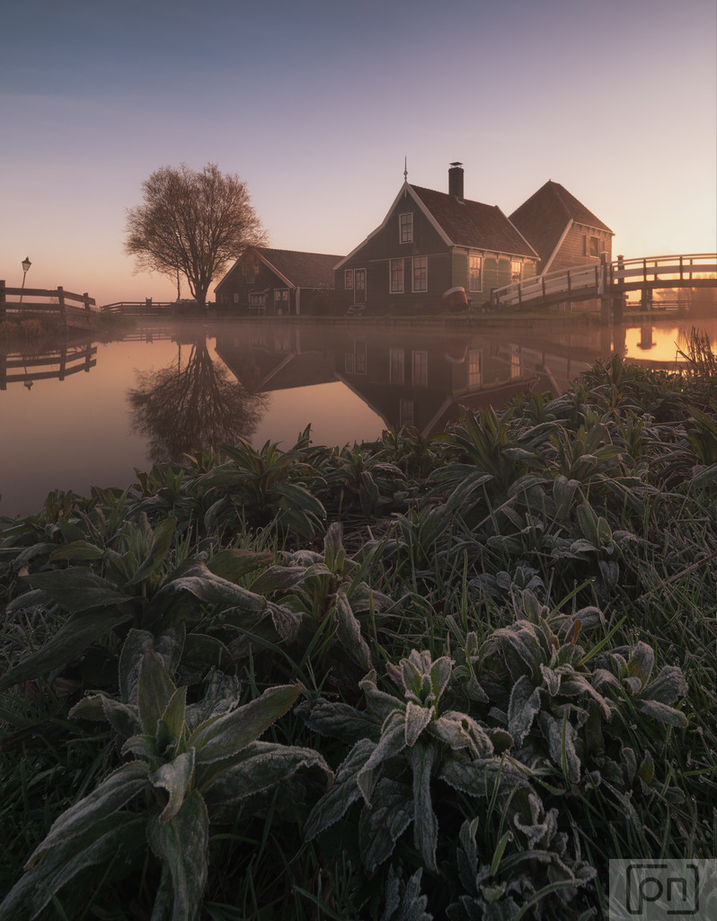 Zaanse Schans | "Zaanse Schans Fotos" präsentieren eine zauberhafte Reise in die Vergangenheit der Niederlande. Die Zaanse Schans ist ein malerisches Dorf, das sich in der Nähe von Amsterdam befindet und als lebendiges Freilichtmuseum bekannt ist. Die Fotos zeigen die einzigartige Atmosphäre dieses historischen Ortes, der eine Fülle von traditionellen Windmühlen, Holzhäusern, Brücken und Kanälen umfasst.

Die Windmühlen sind zweifellos die Hauptattraktion der Zaanse Schans. Die Fotos fangen die majestätische Präsenz dieser Windmühlen ein, die einst das industrielle Herz der Region bildeten. Jede Mühle hat ihre eigene Geschichte und diente einst verschiedenen Zwecken wie dem Mahlen von Getreide, dem Sägen von Holz oder der Herstellung von Farben und Ölen.

Die Bilder zeigen auch die charakteristischen grünen Holzhäuser, die typisch für die niederländische Architektur sind und eine gemütliche und idyllische Atmosphäre schaffen. Die Schönheit der Zaanse Schans wird durch die Spiegelungen der Häuser in den Kanälen verstärkt, die eine malerische Kulisse für die Fotografien bieten.

Die Fotos erfassen die Traditionen und das Handwerk der Vergangenheit, die in der Zaanse Schans lebendig gehalten werden. Besucher haben die Möglichkeit, Handwerker bei der Arbeit zu beobachten und alte Techniken wie das Herstellen von Holzschuhen, Käse und Schokolade zu erleben.

Inmitten dieser charmanten Kulisse fangen die Fotos das Gefühl von Ruhe und Nostalgie ein, das die Zaanse Schans so besonders macht. Es ist eine Zeitreise in die niederländische Geschichte und Kultur, die Besucher und Betrachter gleichermaßen verzaubert und inspiriert.

Ob Sie von der Erkundung historischer Stätten fasziniert sind oder einfach nur die Schönheit und den Charme der Zaanse Schans bewundern möchten, diese Fotos bieten einen unvergesslichen Einblick in diese einzigartige Perle der niederländischen Landschaft