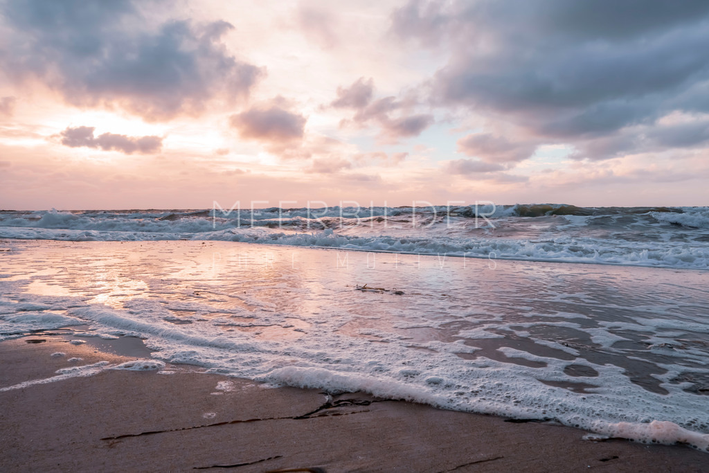 Ostseestrand mit Wellen | Dieses Strandbild zeigt sanfte Wellen mit Schaum an der Ostsee. Die Aufnahme wurde am späten Nachmittag gemacht. Die letzten Sonnenstrahlen scheinen durch die Wolken und spiegeln sich im Spülsaum wider. Im unteren Teil des Bildes ist eine leichte Unschärfe zu erkennen. Diese Aufnahme eignet sich besonders gut für den Druck auf Alu-Dibond oder als Alu-Dibond Butlerfinish® mit gebürstetem Metalleffekt, in Acrylglas oder auf edlem FineArt Hahnemühle Papier in einem Wechselrahmen.