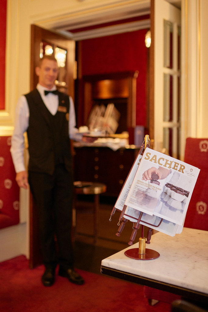 Café Sacher, Kellner serviert eine Sachertorte | Wien, Austria - August 22, 2017: Café Sacher, Kellner serviert eine Sachertorte. - Realisiert mit Pictrs.com