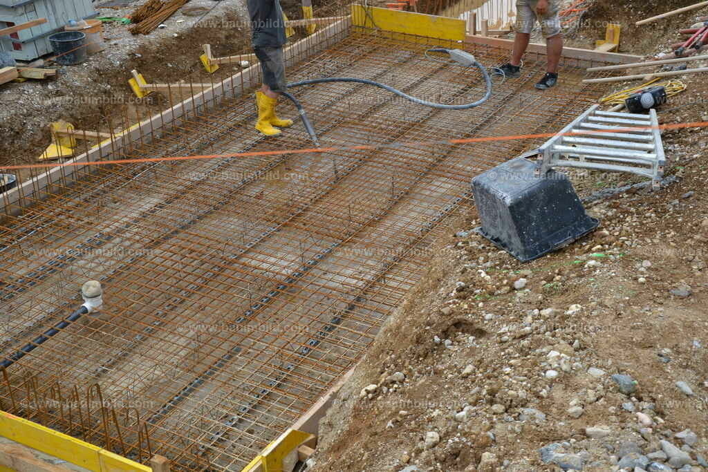 Fundamentplatte | Arbeiter mit Betonrüttler in betonierfertiger Fundamentplatte